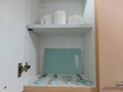 a cabinet with scissors and cups on a shelf at Bunked Bed Room Sharing in Manila