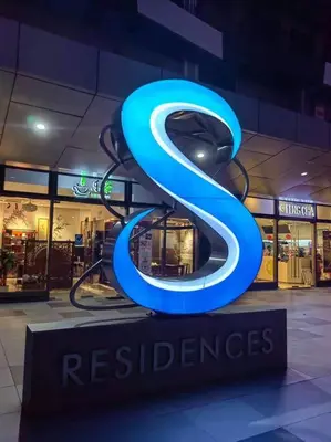 a large blue s sign in front of a store at MoA S Residences Family Suite with balcony in Manila