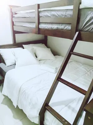 a bedroom with a bunk bed with white sheets at MoA S Residences Family Suite with balcony in Manila