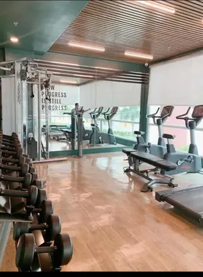 a gym with several treadmills and exercise bikes in it at Lancris Residences 2 Bedroom Entire Apartment near Airport with Pool in Manila