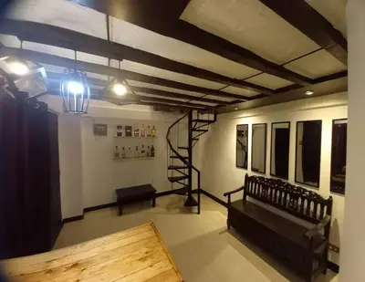 a room with a staircase and a bench in a room at Adorable Lounge - 1 Bedroom loft w/home cinema in Manila