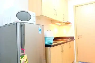a kitchen with a refrigerator and a microwave on top of it at StayHere SM Light by Boni MRT along EDSA in Manila