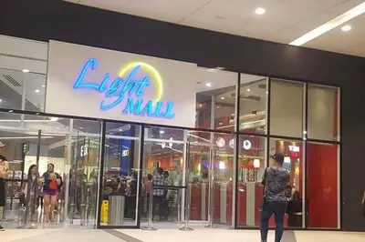 a woman standing in front of a light mall at StayHere SM Light by Boni MRT along EDSA in Manila