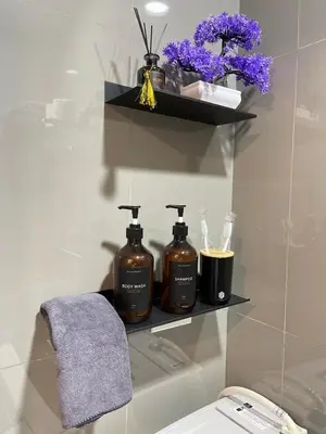 a bathroom with three bottles of soap on a shelf at Amazing view Makati Elegant flat 400MB internet in Manila