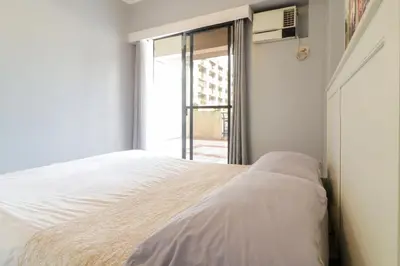 a bedroom with a bed and a window at StayHere - Nordic Design 2BR Serviced Apartment in Manila