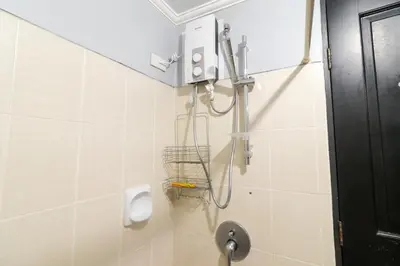 a bathroom with a urinal and a toilet in it at StayHere - Nordic Design 2BR Serviced Apartment in Manila