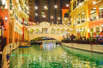 a canal in a city with a bridge and buildings at Venice Luxury Residences in Manila