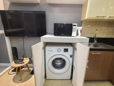 a washing machine in a kitchen with a microwave at Venice Luxury Residences in Manila