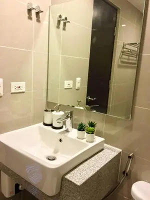 a bathroom with a white sink and a mirror at Daniella’s Modern & Cozy Suite in Uptown BGC in Manila
