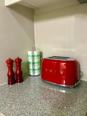 a red toaster sitting on top of a counter at Daniella’s Modern & Cozy Suite in Uptown BGC in Manila