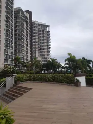 a parking lot with two tall buildings and palm trees at Fully furnished condo in Quezon City in Manila