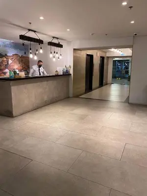 a man standing at a counter in a lobby at Fully furnished condo in Quezon City in Manila