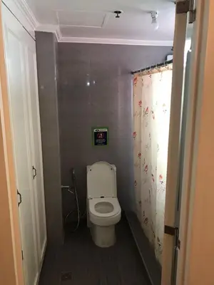 a bathroom with a toilet with a shower curtain at Alta Vitas Daily in Manila