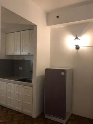 a kitchen with white cabinets and a black refrigerator at Alta Vitas Daily in Manila
