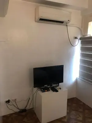 a flat screen tv sitting on a stand in a room at Alta Vitas Daily in Manila