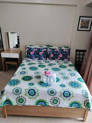 a bed with a flowered blanket with a tray on it at Room Across NAIA Terminal 3 at Newport in Manila