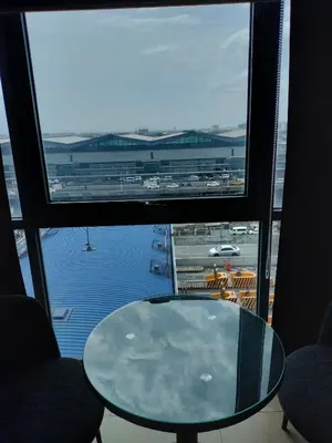 a glass table in front of a large window at Room Across NAIA Terminal 3 at Newport in Manila