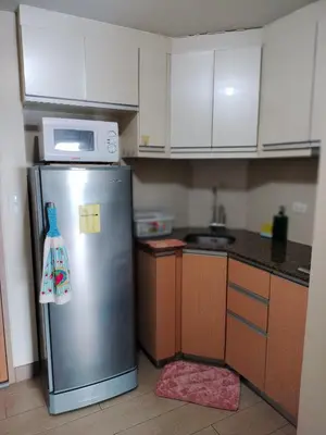 a kitchen with a stainless steel refrigerator and a microwave at Room Across NAIA Terminal 3 at Newport in Manila