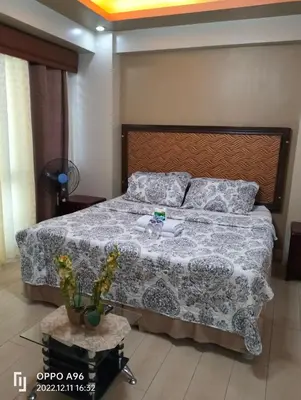 a bedroom with a large bed with a blanket and pillows at Staycation Near Airport and resorts World Manila in Manila
