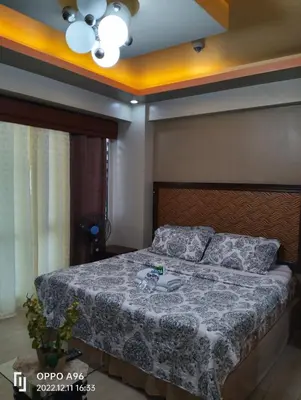 a bedroom with a bed and a ceiling fan at Staycation Near Airport and resorts World Manila in Manila