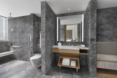 a bathroom with a sink and a toilet and a mirror at The Westin Manila in Manila