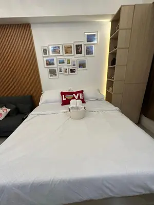 a bedroom with a large white bed in a room at Homey Condo by the Bay in Manila