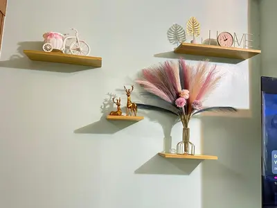 a wall with three shelves with a vase with flowers at Kathys crib 32sqm Condo Shell Residences in Manila