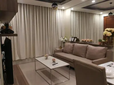 a living room with a couch and a table at Adria Residences - Sapphire Garden - 2 Bedroom for 4 person in Manila