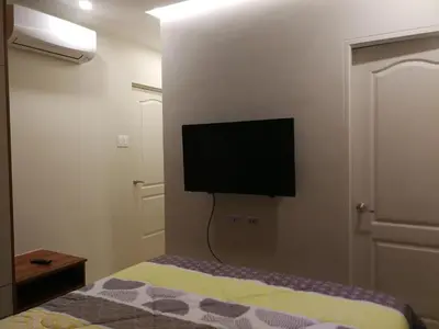 a bedroom with a bed with a flat screen tv on the wall at Adria Residences - Sapphire Garden - 2 Bedroom for 4 person in Manila