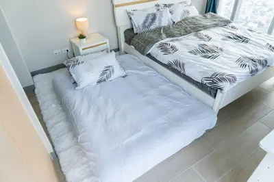 two beds sitting next to each other in a bedroom at A2J Luxury 3BR Uptown Balcony BGC Suite Near Mall in Manila