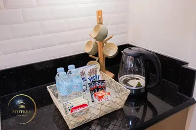 a kitchen counter with a tray of drinks and a coffee maker at MOA Shore 3 New Modern One bedroom Condo in Manila