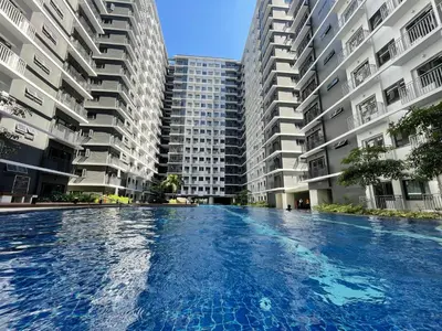 a large swimming pool in front of two tall buildings at MOA Shore 3 New Modern One bedroom Condo in Manila