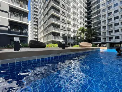 a large swimming pool in front of two tall buildings at MOA Shore 3 New Modern One bedroom Condo in Manila