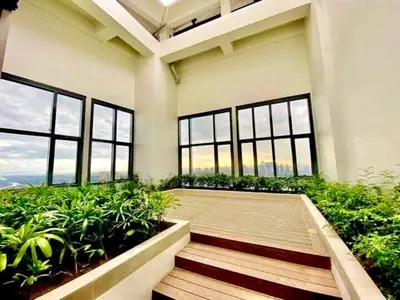 a room with a balcony with plants and windows at AFFORDABLE StayCation EASTWOOD CITY in Manila