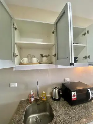 a kitchen counter with a sink and a microwave at AFFORDABLE StayCation EASTWOOD CITY in Manila