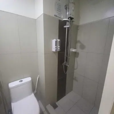 a bathroom with a shower with a toilet and a shower at SMDC Breeze Residences in Manila