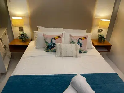 a large white bed with pillows on it at Lux Skyline KL Greenbelt, Isabel's Makati Rooms in Manila