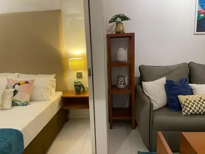 a small bedroom with a bed and a chair at Lux Skyline KL Greenbelt, Isabel's Makati Rooms in Manila