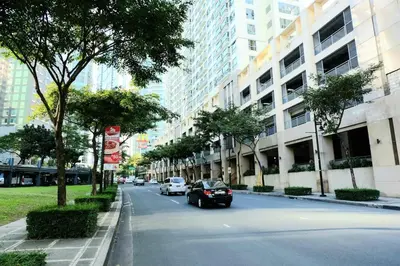 a city street with cars driving down a street with buildings at Avant in BGC - Spacious 1 Bedroom with Amazing View in Manila