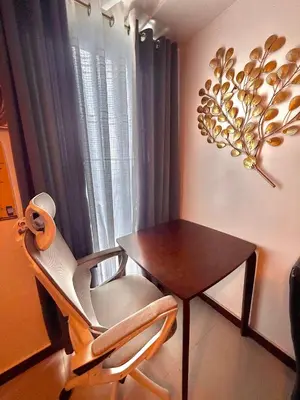 a chair and a table in a room with a window at 1 Bedroom Bayview Condo near SLMEC & US Embassy in Manila