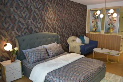 a bedroom with a bed and a couch and a chair at Luxxe interior design condo - Residences at Acqua private residences in Manila