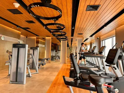 a gym with many treadmills and a person in the background at Luxxe interior design condo - Residences at Acqua private residences in Manila