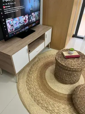 a living room with a large rug and a television at Cozy Studio Viceroy Residences McKinley Hill Bgc in Manila
