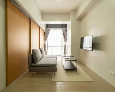 a living room with a chair and a window at StayHere Skandanavian Designed 1BR in Greenbelt in Manila