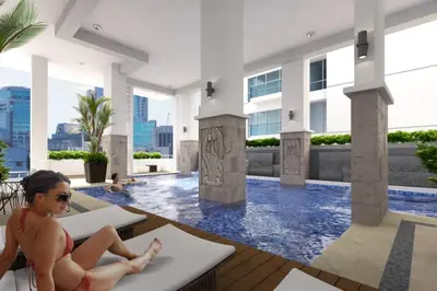 a woman in a swimming pool at a hotel at StayHere Skandanavian Designed 1BR in Greenbelt in Manila