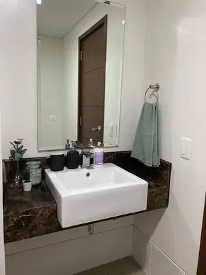 a bathroom with a white sink and a mirror at Modern and homely Condo in Shaw Boulevard in Manila