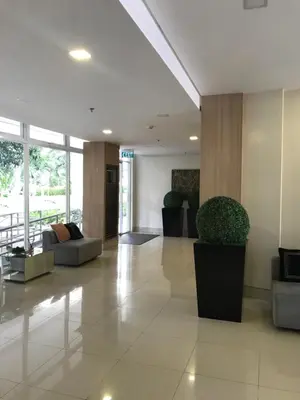 a lobby with couches and plants in a building at South Residences staycation in Manila