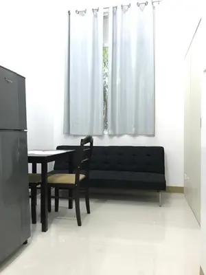 a living room with a black couch and a table at South Residences staycation in Manila