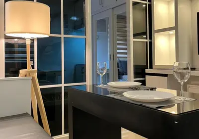 a dining room with a table with wine glasses on it at Victoria Suite at Shore Residences in Manila