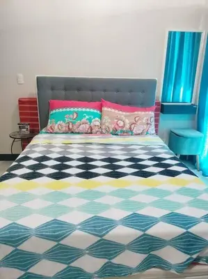 a bedroom with a bed with a black and white checkered floor at Cubao Manhattanheights U31N TB, Studio Unit in Manila